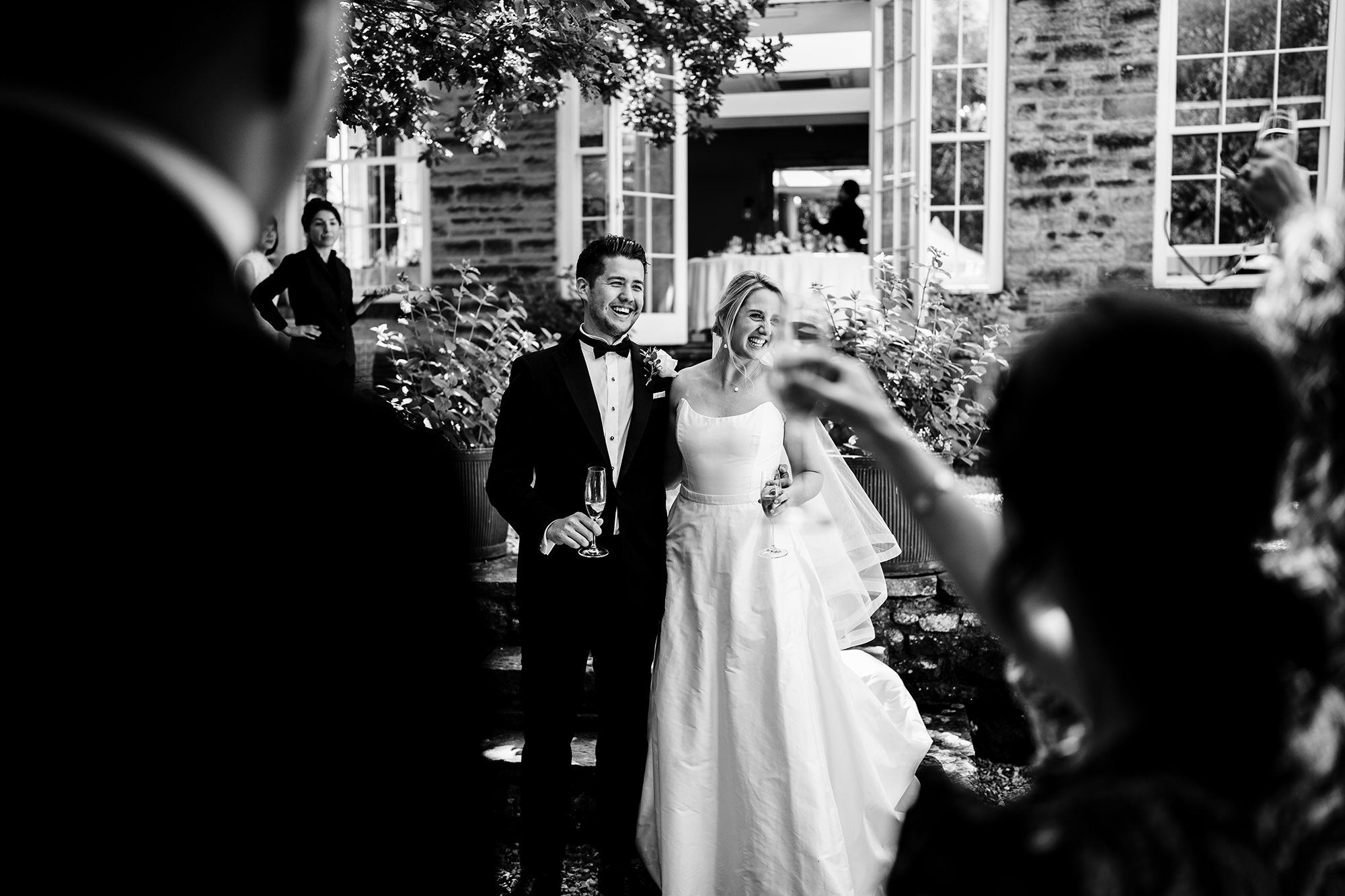 Couple seen through wedding guests in a documentary style photograph