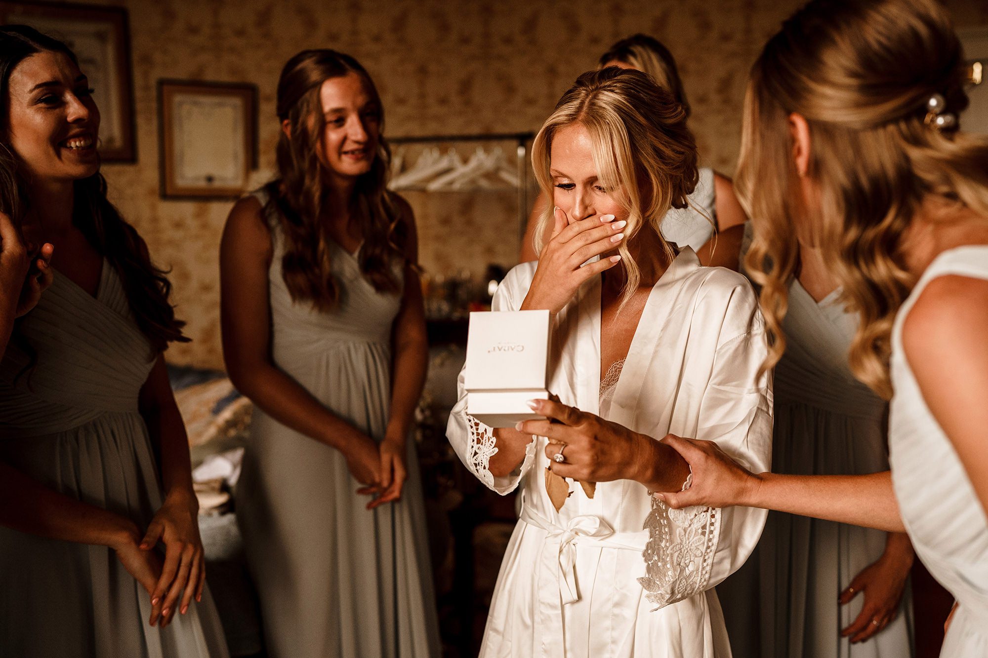 Bride opening a wedding gift during morning preparations