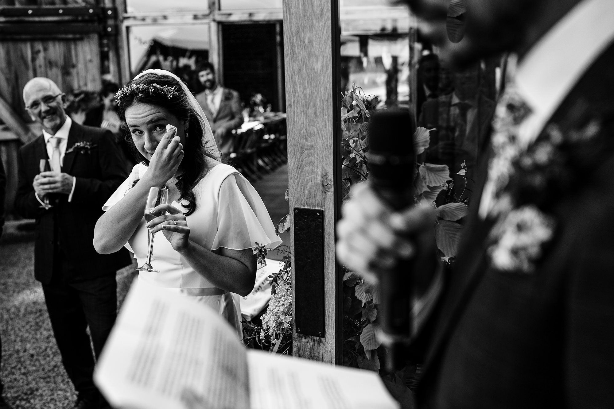 Emotional bride wiping away tears during speeches at a Cotswolds wedding