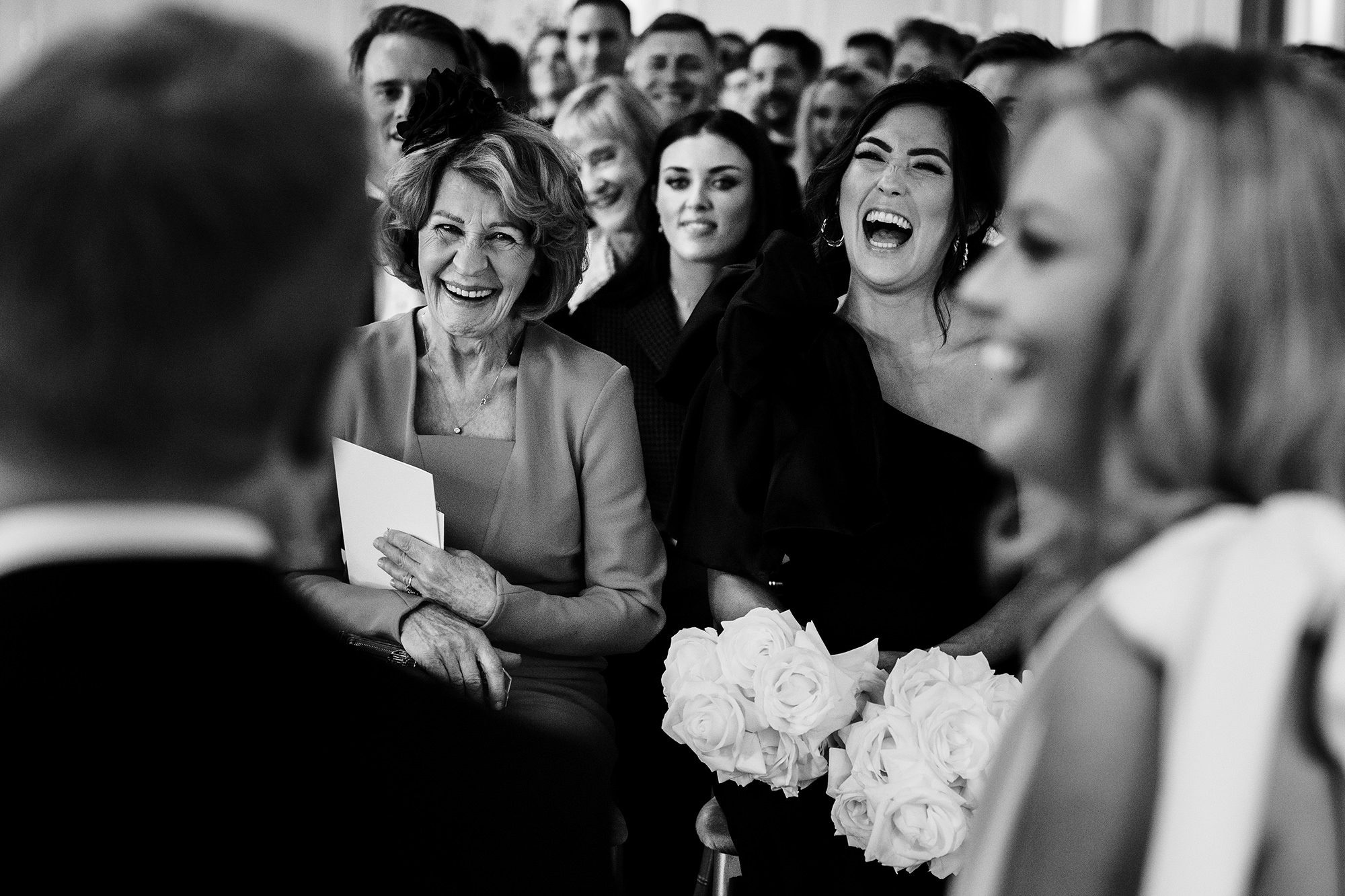 Guests laughing during a wedding ceremony in the Cotswolds