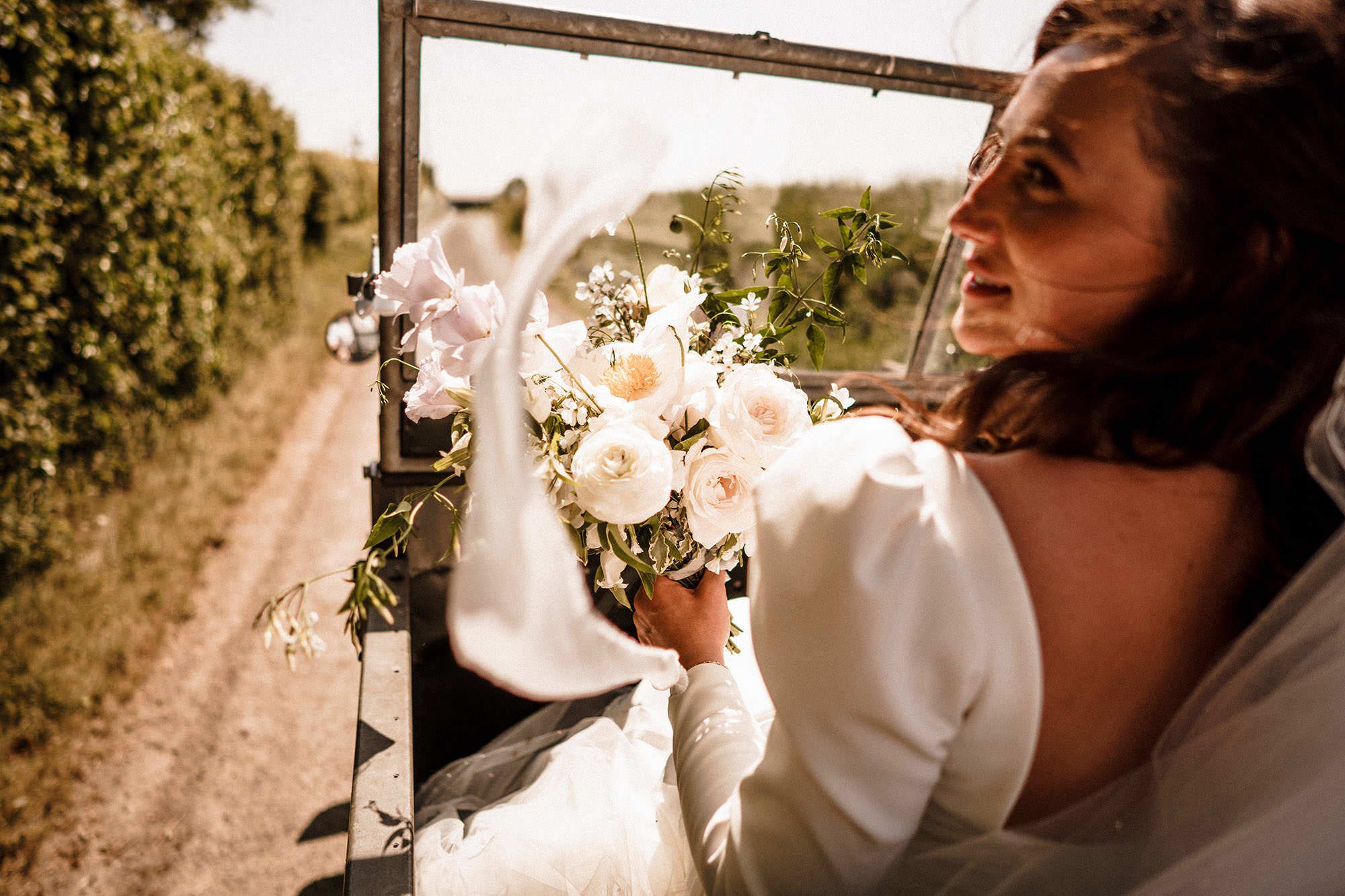 Bride standing in window light during wedding morning